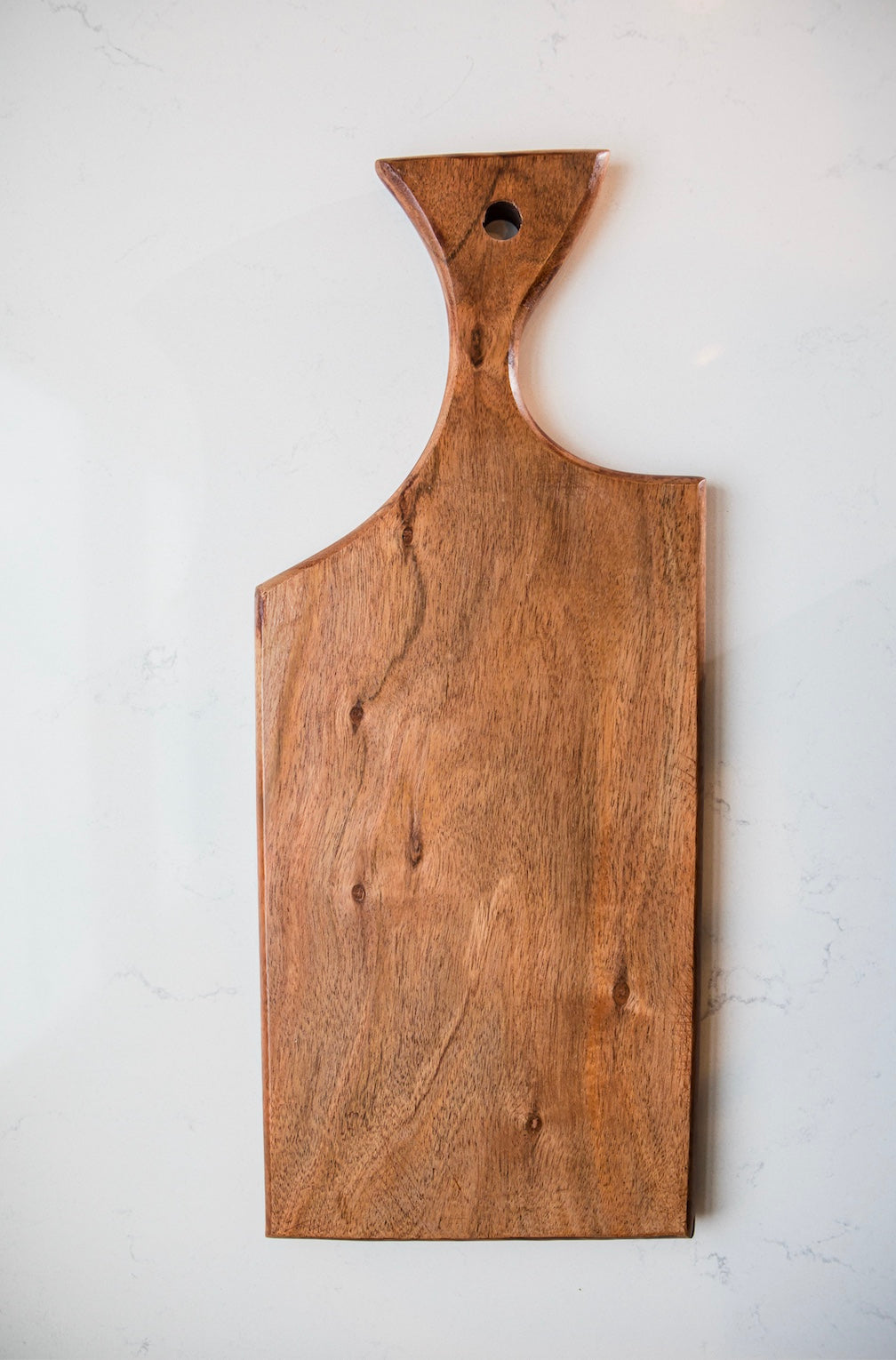 Wooden cutting board with handle on a white background