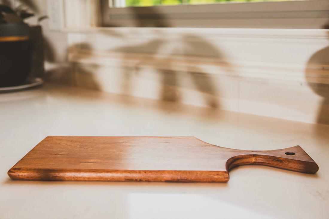 Wooden cutting board on a kitchen counter with a blurred background