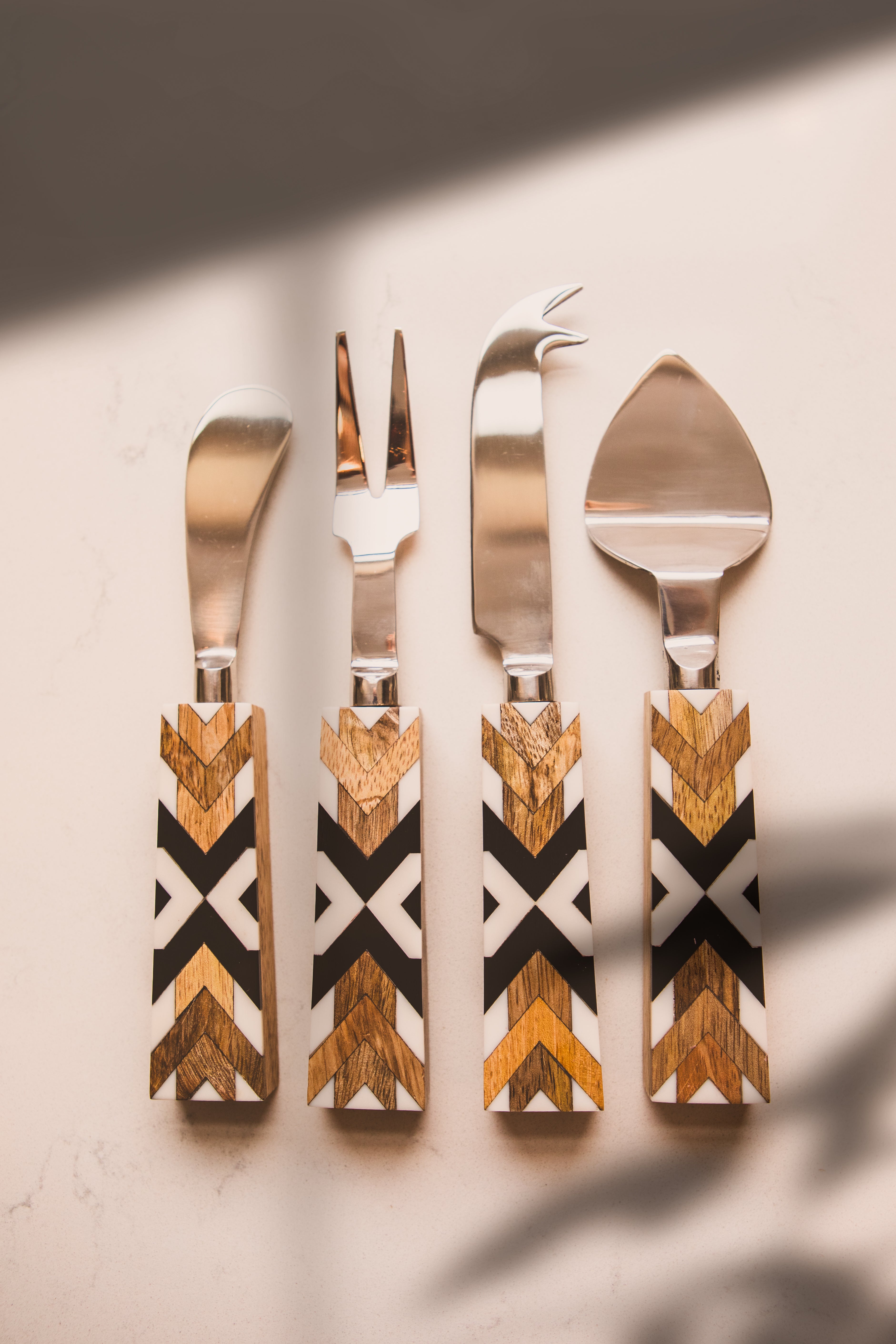 Set of four wooden-handled cutlery on a neutral background
