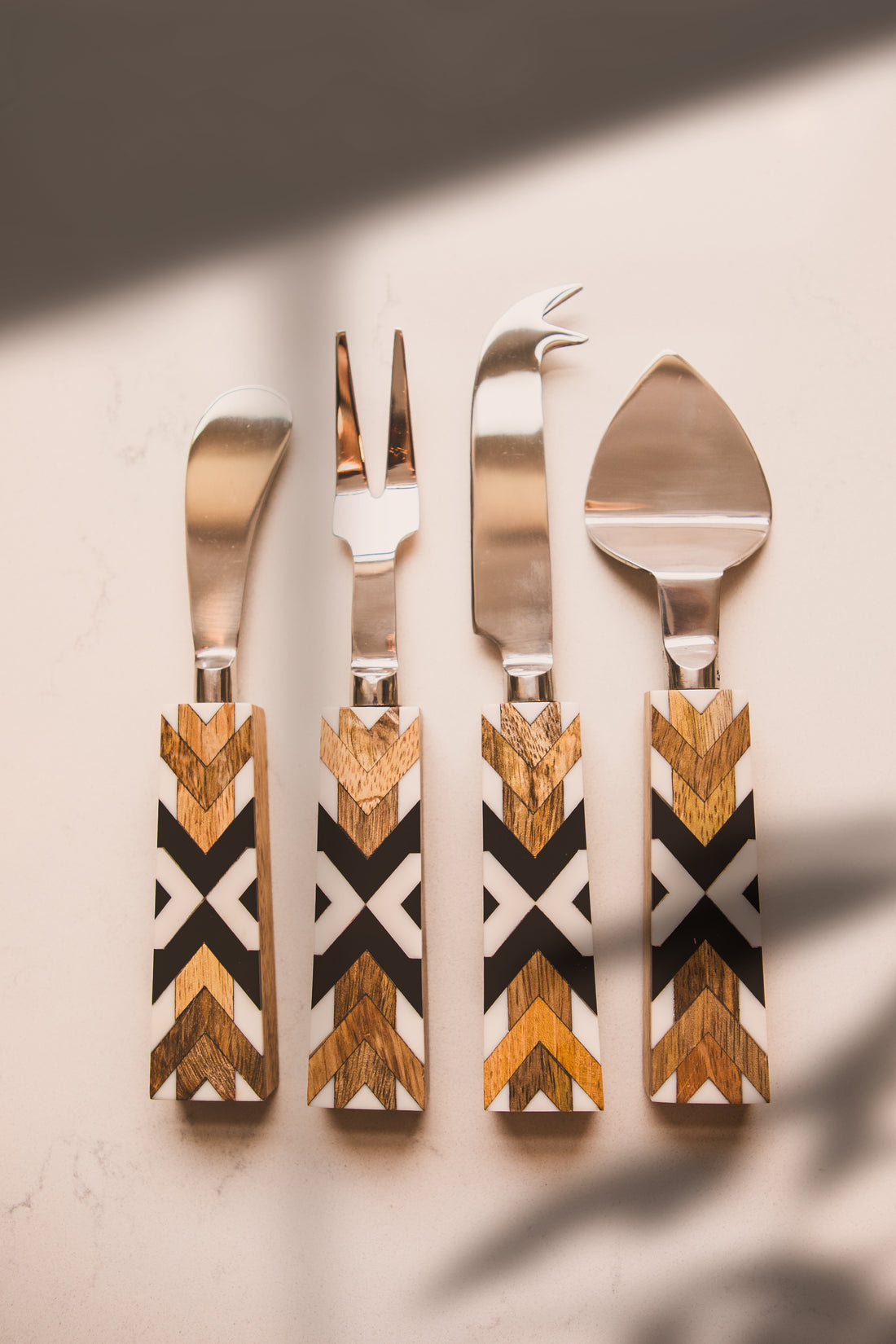 Set of four wooden-handled cutlery on a neutral background