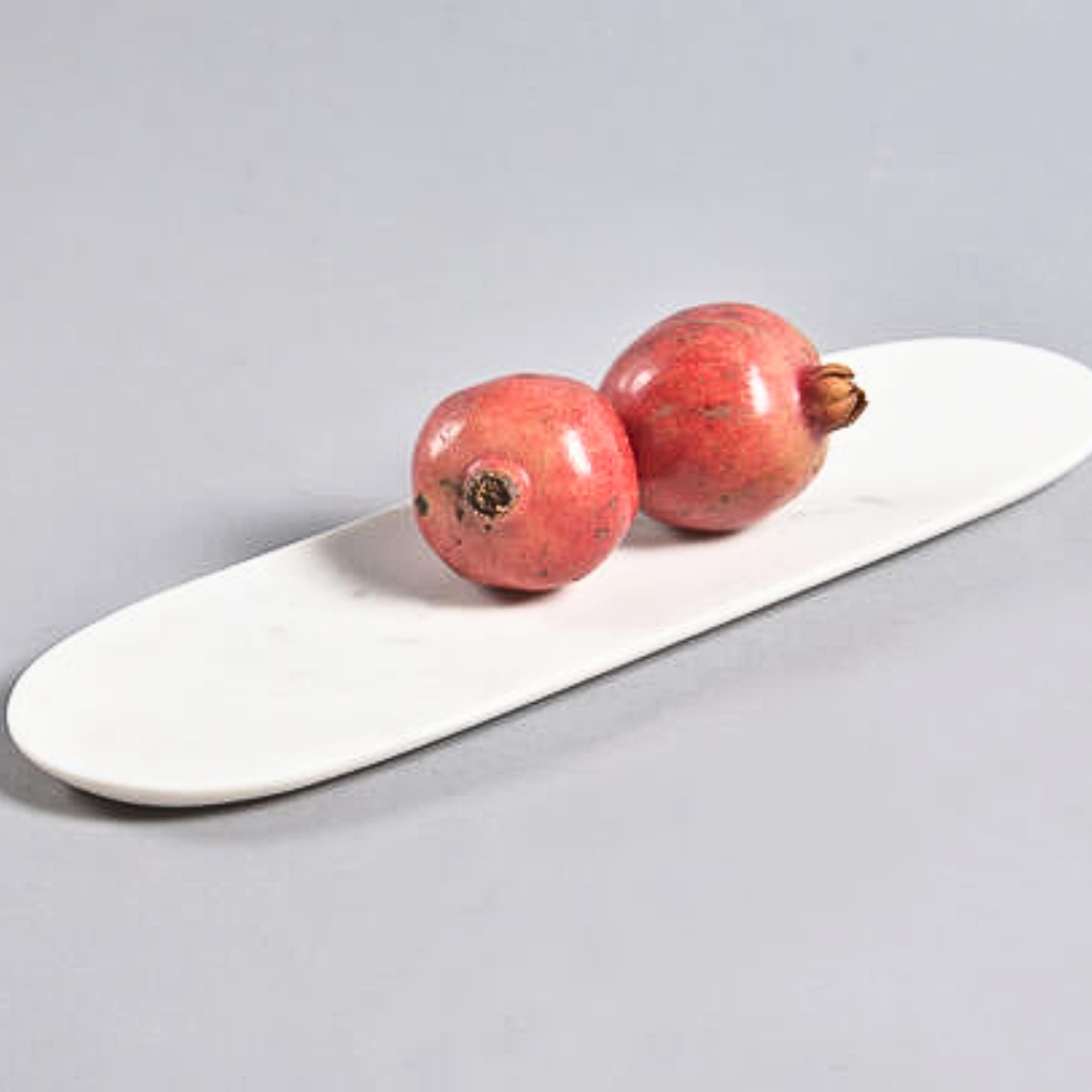 Two hand-cut marble serving trays placed on a white, smooth surface with a grey background.