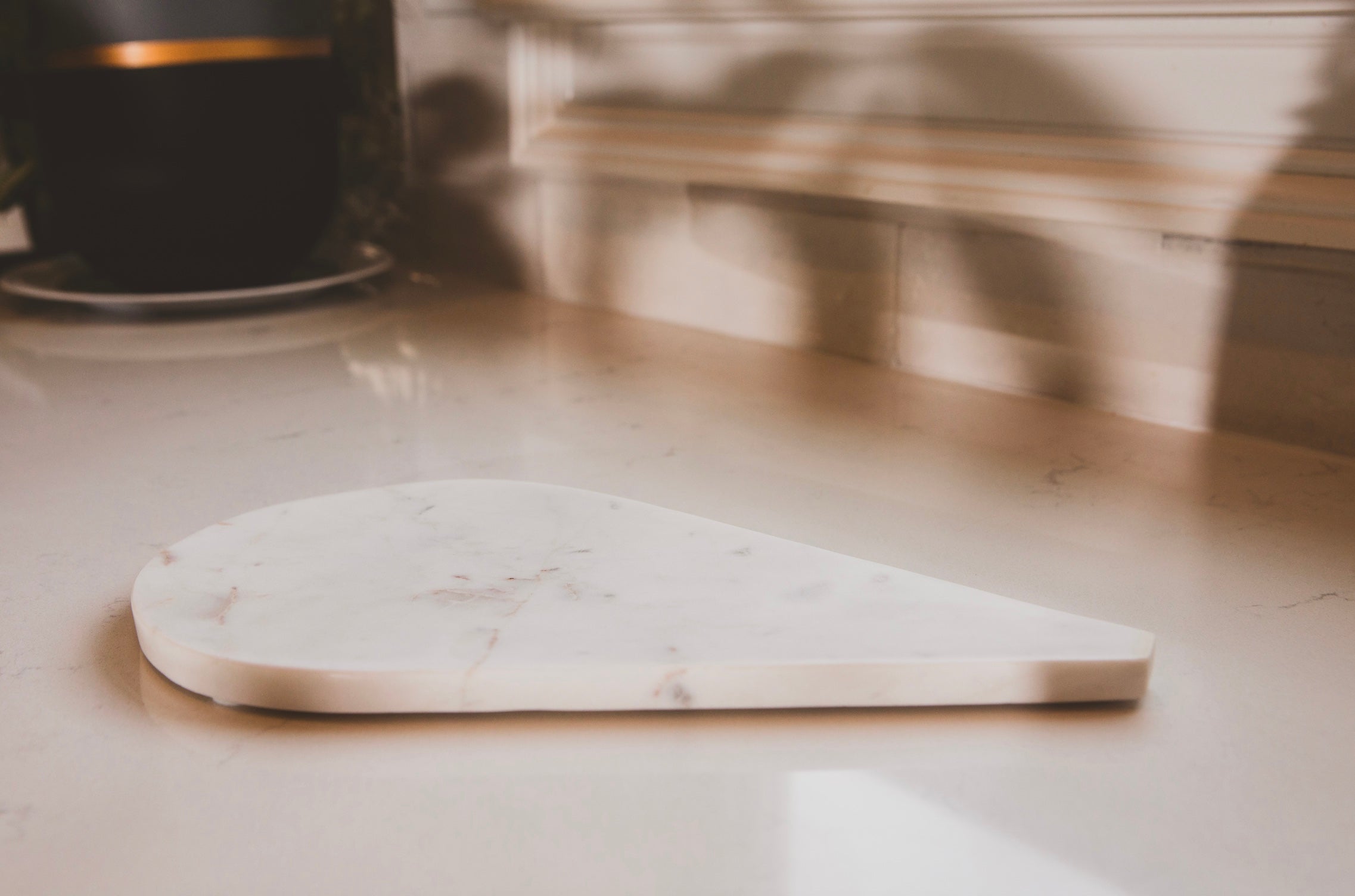 Marble cutting board on a kitchen counter with a blurred background