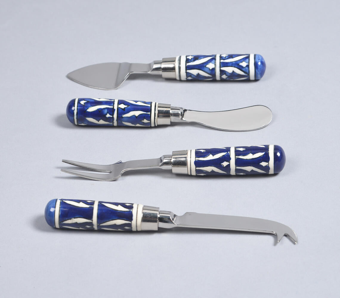 A set of cheese utensils with blue and white patterned handles and stainless steel blades, including a knife, fork, and a small opener.