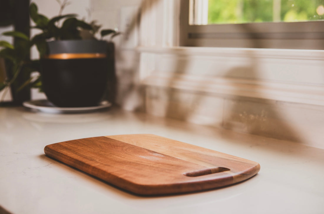 Wooden cutting board on a kitchen counter with a blurred background