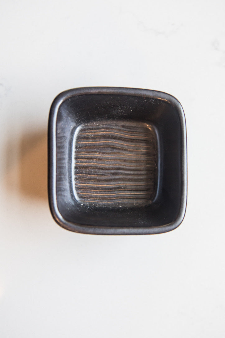 Black ceramic square bowl on a white background